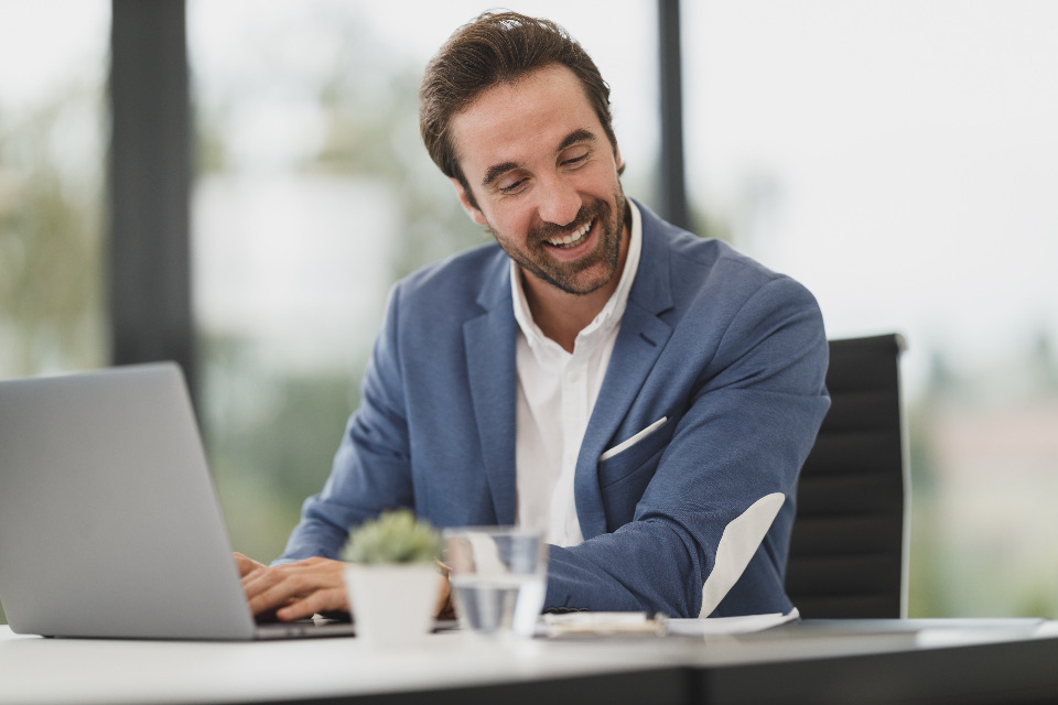 Smiling advisor working on a laptop